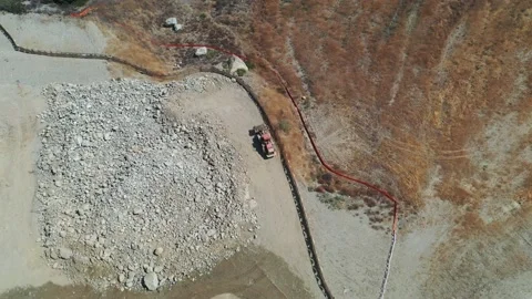 Aerial View of Wheel Loader driving towards rock pile Stock Footage 137419663