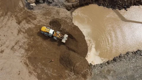 Aerial view of wheel loader pushing gravel into water Stock Footage 344959556