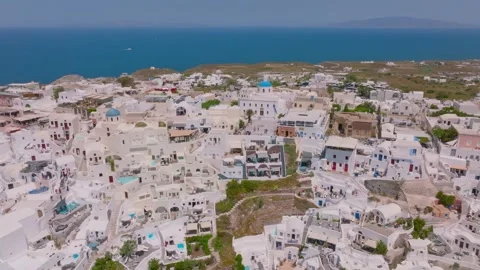 Aerial view of white architecture, blue-domed churches, and caldera Stock Footage 341460626