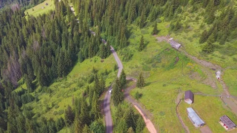 Aerial view of a white camper van driving along a serpentine mountain road past Stock Footage 342324395