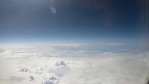 Aerial view of white clouds and blue sky from plane window Stock-Footage 121354841