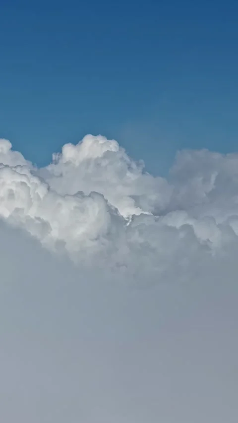 Aerial view of white clouds floating over a beautiful clear blue sky during the Stock Footage 339646987