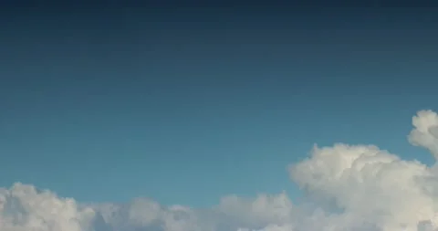 Aerial view of white clouds flying across the blue sky Stock Footage 170762572