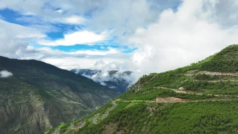 Aerial view of white clouds hanging over layered green mountain terraces in deep Video stock 336698813