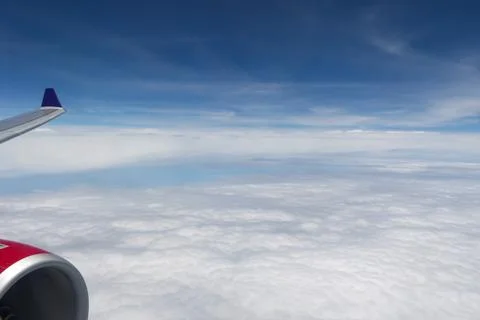 Aerial View of White Clouds Under Blue Sky with Airplane Wing and Engine Stock Photos