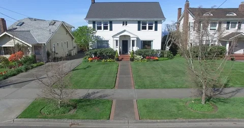 Aerial view of a white colonial house with fly over showing view and backyard Stock Footage