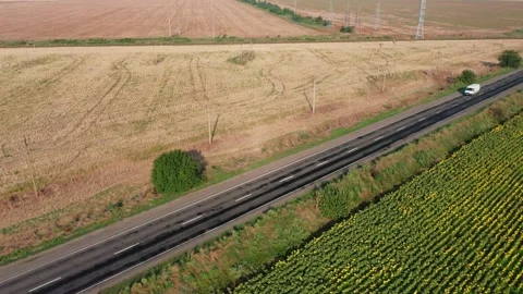 Aerial view of a white minivan driving along a road on a summer morning. Stock Footage 169100271