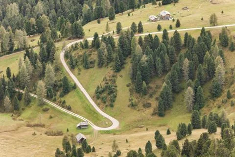Aerial view of a white road among a wide pasture in Dolomites area Italy Stock Photos