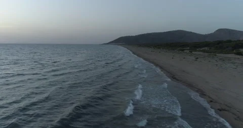 Aerial view of a wide, empty beach at sunset Stock Footage 233959381