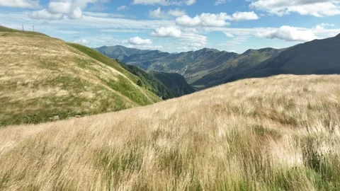 Aerial view of a wide mountain valley featuring yellow dry grasslands Stock-Footage 323345967
