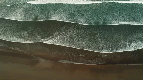 Aerial view of wide ocean waves creating parallel lines on chocolate sandy beach Stock-Footage 321456740