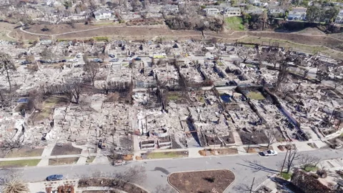 Aerial view of wildfire damage in Pacific Palisades neighborhood of Los Angeles Stock Footage 301584059