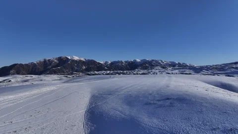 Aerial view of wind blowing snow across a vast winter landscape Stock Footage 321735409