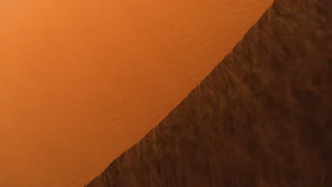 Aerial view of wind dusting sand over dunes in the Namib desert, in sunny Stock Footage 241763184