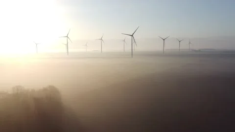Aerial view of a wind farm at dawn with mist Stock Footage