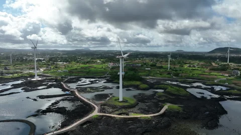 Aerial view of wind farm generating renewable energy on volcanic coastline Vidéo 346715863