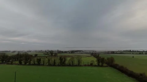 Aerial View of Wind Farm Over Green Farmland Under Dramatic Sky Stockbeeldmateriaal 332569038