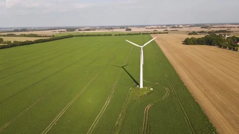 Aerial view of wind turbine between green and golden fields in summer Stockbeeldmateriaal 325006830