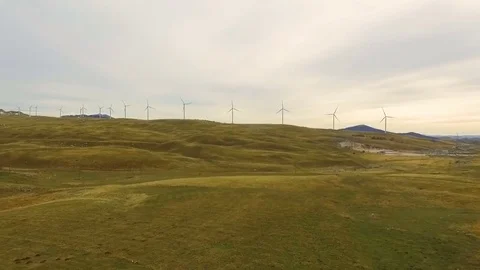 Aerial View of Wind Turbine Fields with cloudy sky in the background Stock Footage 82328119