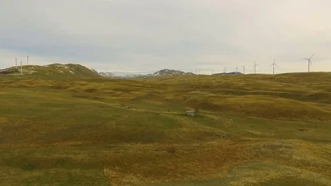 Aerial View of Wind Turbine Fields with cloudy sky in the background Stock Footage 82329350