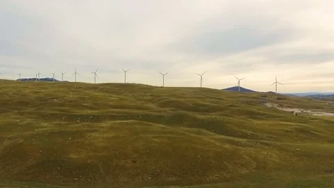 Aerial View of Wind Turbine Fields with cloudy sky in the background Stock Footage 82329843