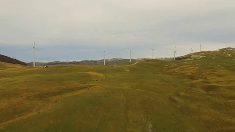 Aerial View of Wind Turbine Fields with cloudy sky in the background Stock Footage 82330260