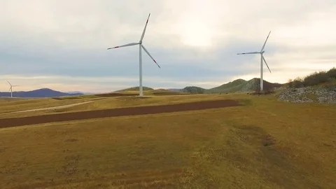 Aerial View of Wind Turbine Fields with cloudy sky in the background Stock Footage 82336130