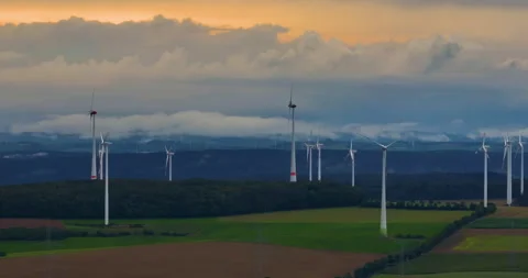 Aerial view of wind turbines in corn fields in Germany. Clouds over a green Stock Footage 253786304