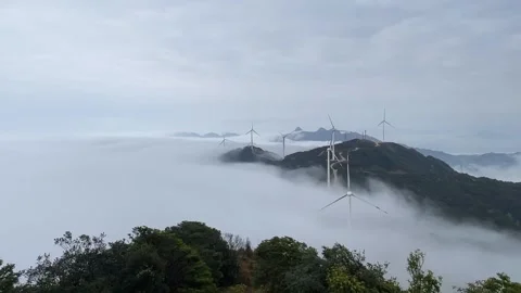 Aerial View of Wind Turbines Emerging from Thick Sea of Clouds Stock Footage 330142357