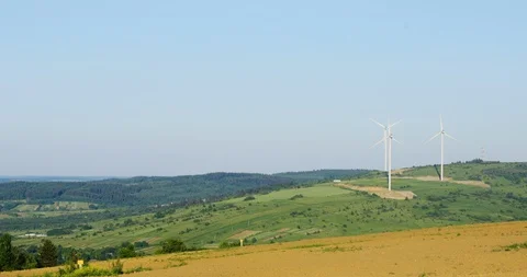 An aerial view of wind turbines functioning on mountain hillside in sunny summer Video stock 91467333