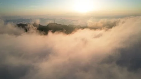 Aerial view of wind turbines on mountain ridge above sea of clouds at sunrise Stock Footage 341949722