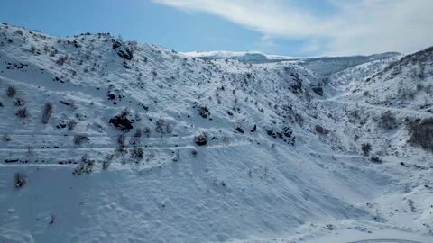 Aerial View of Winding Highway Through Snow-Covered Mountains 動画素材 330168040