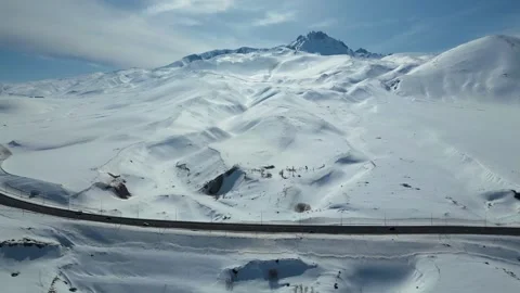 Aerial View of Winding Highway Through Snow-Covered Mountains 库存影片 330168914