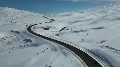 Aerial View of Winding Highway Through Snow-Covered Mountains 库存影片 330168980