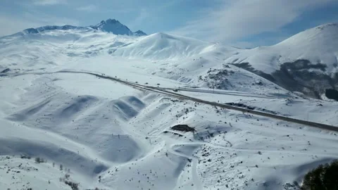 Aerial View of Winding Highway Through Snow-Covered Mountains 库存影片 330169232