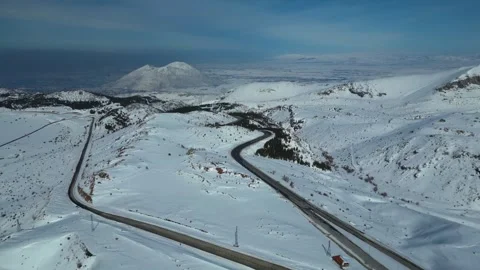 Aerial View of Winding Highway Through Snow-Covered Mountains 库存影片 330169377