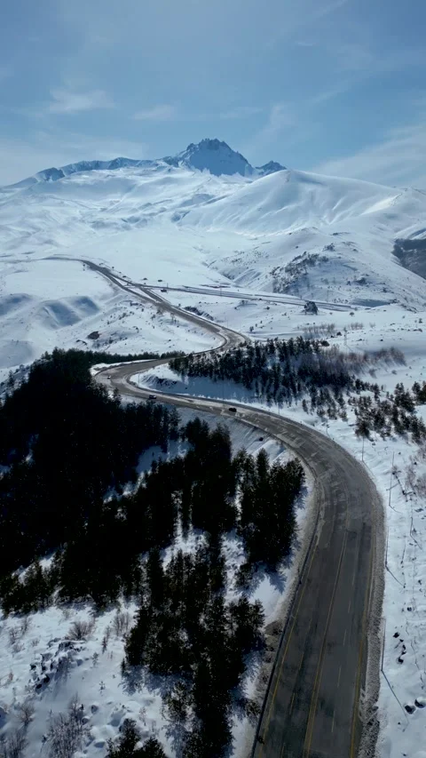Aerial View of Winding Highway Through Snow-Covered Mountains 库存影片 330169480