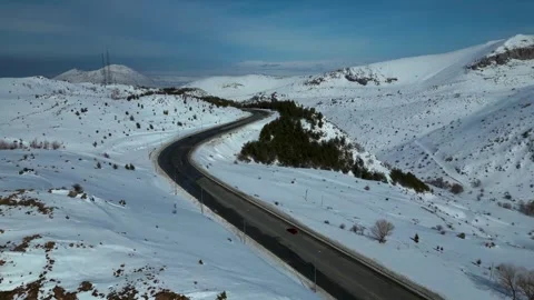 Aerial View of Winding Highway Through Snow-Covered Mountains 库存影片 330169633