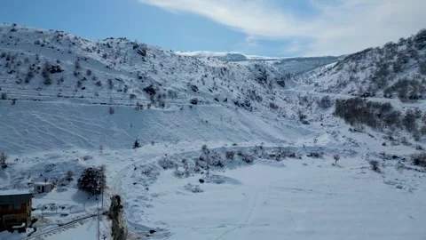 Aerial View of Winding Highway Through Snow-Covered Mountains 库存影片 330169848