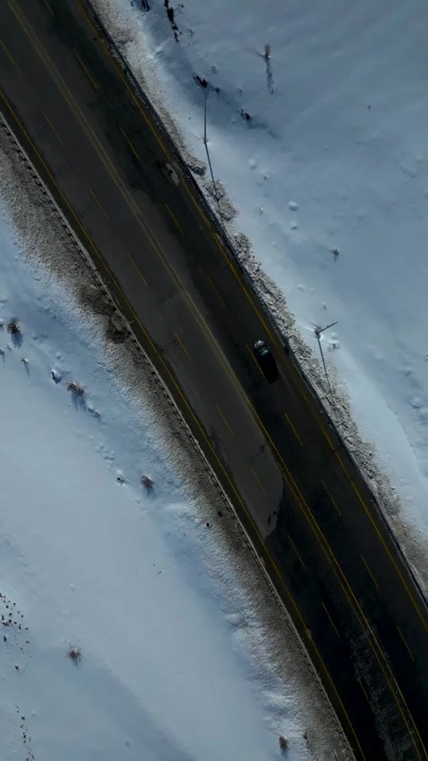 Aerial View of Winding Highway Through Snow-Covered Mountains 库存影片 330169849