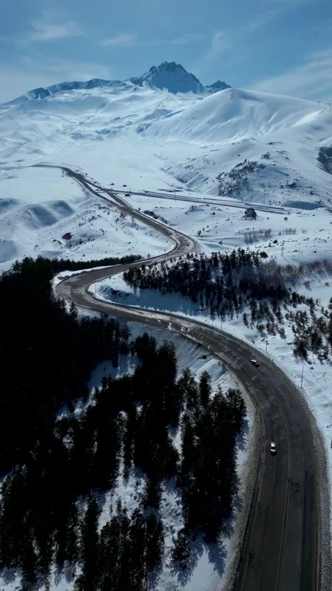 Aerial View of Winding Highway Through Snow-Covered Mountains 库存影片 330169897