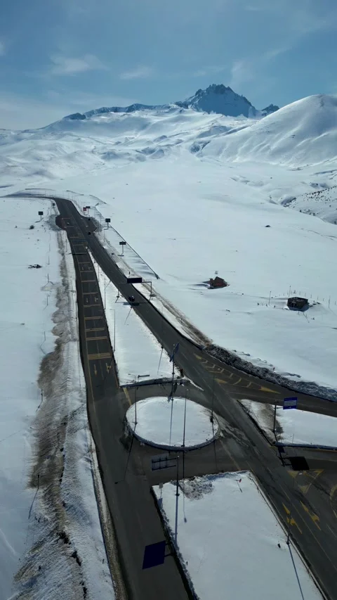 Aerial View of Winding Highway Through Snow-Covered Mountains 库存影片 330169898