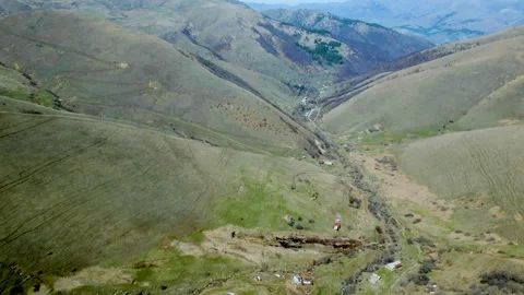 Aerial view of winding mountain river valley Snow thawed along the banks, houses Video stock 257426842