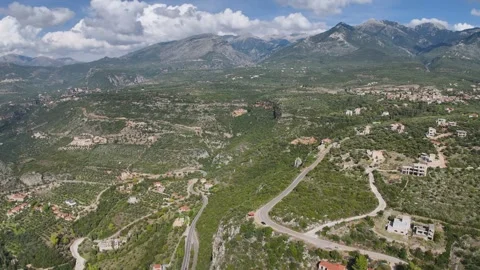 Aerial View of Winding Mountain Road in Greek Valley with Village Stock-Footage 331070892
