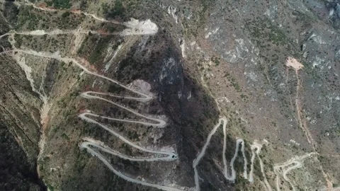 Aerial View of Winding Mountain Road Through Rugged Canyon Landscape Video stock 342114814
