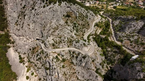 Aerial view of a winding mountain road through the Croatian landscape Stock Footage 345118876