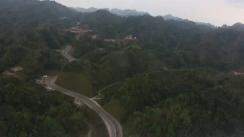 Aerial view of winding mountain road through green hills Vídeo Stock 346138420