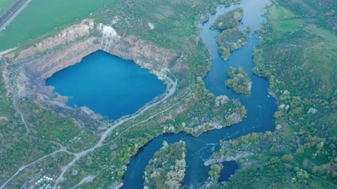 Aerial view of the winding river and flooded quarry among green vegetation. Stock Footage 166807899