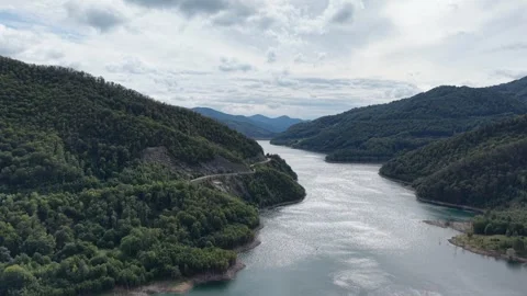 Aerial view of a winding river cutting through a deep green mountain valley Stock Footage 345602707