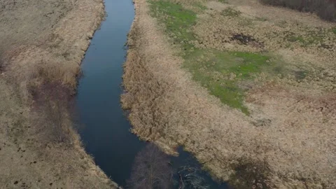 Aerial view of winding river flowing through grassy landscape Stock Footage 333875542